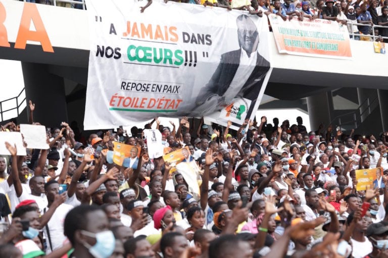 People gather for a ceremony organised by the RHDP political party in homage to the late Prime Minister Hamed Bakayoko at the Olympic Stadium in Abidjan, Ivory Coast, 17 March 2021, Cyrille Bah/Anadolu Agency via Getty Images