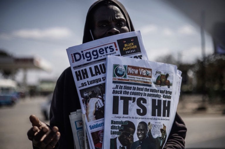 A newspaper vendor carries the dailies announcing Hakainde Hichilema's victory in the elections, in Lusaka, Zambia, 16 August 2021, MARCO LONGARI/AFP via Getty Images